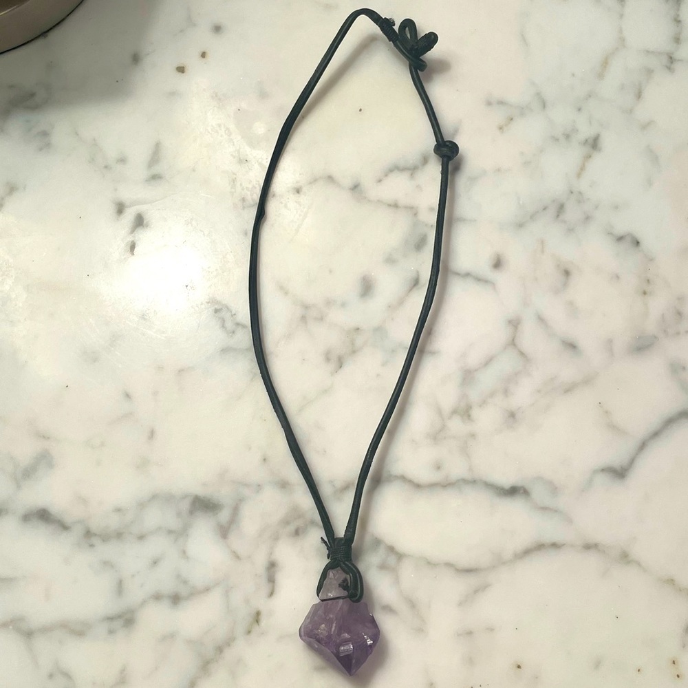 Raw amethyst gemstone necklace attached with adjustable leather cord